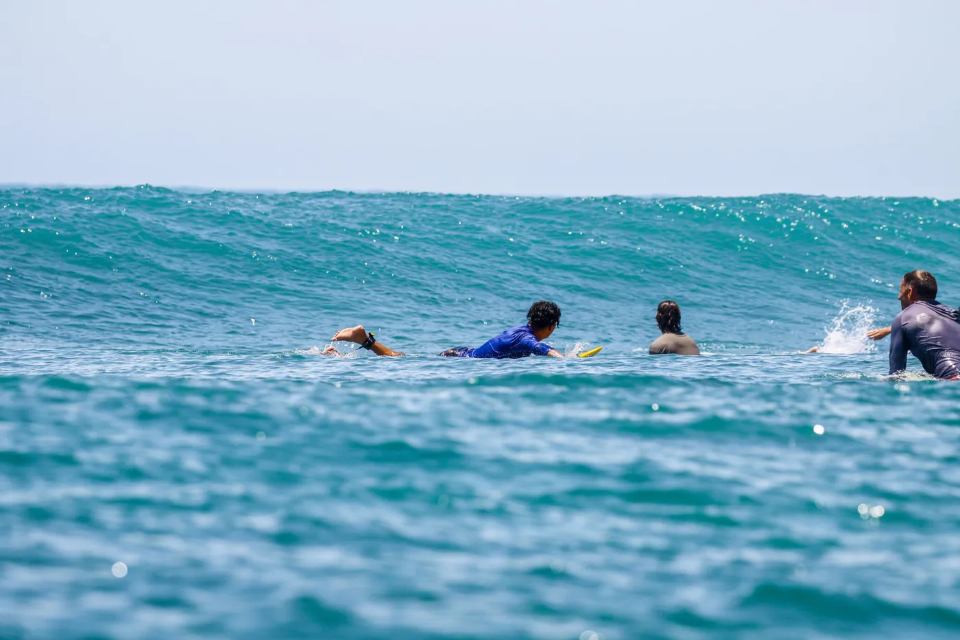 Surfers paddling on boards in the ocean line-up