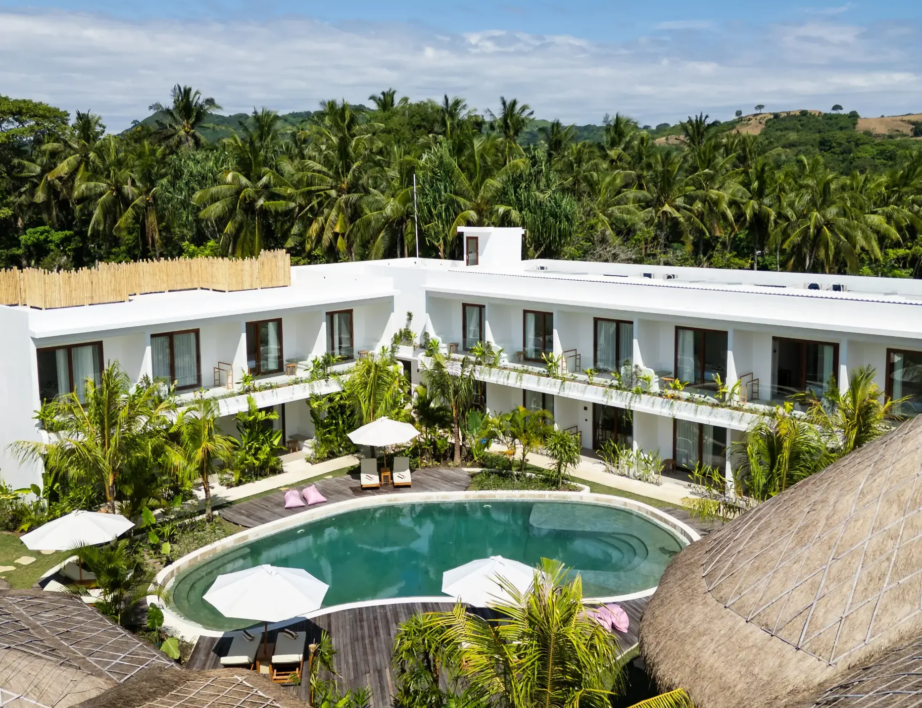 Aerial view of a boutique hotel with pool, surrounded by lush greenery